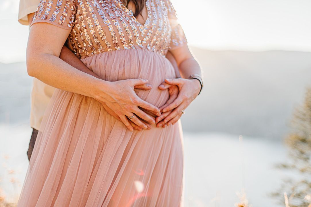 Close-up details of a pink sequined dress during a maternity photoshoot.