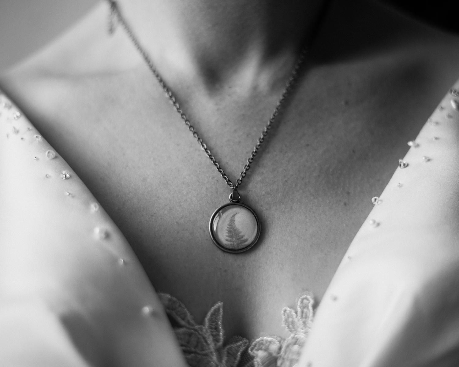 Close-up of a delicate pendant necklace on bare skin.
