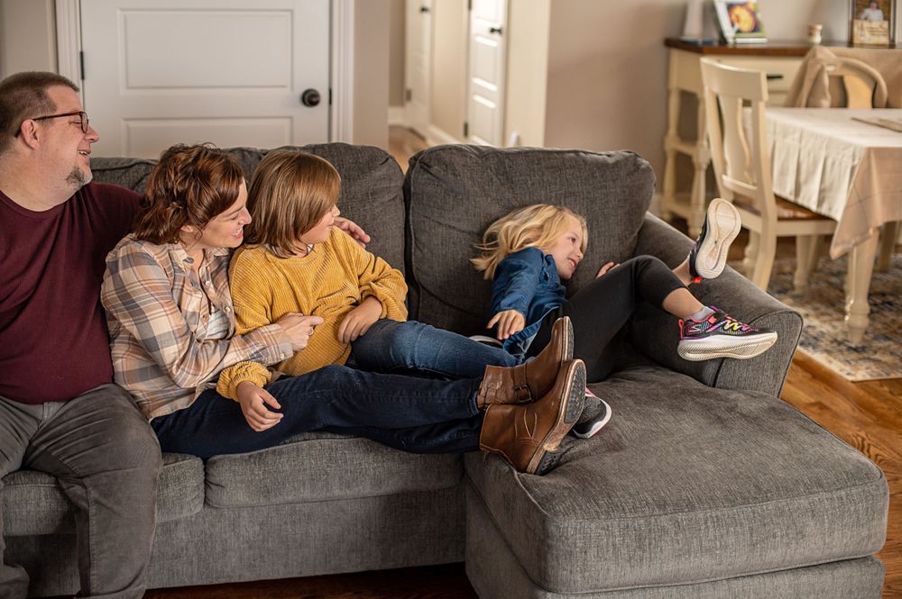 Family members relax together on modern gray sectional sofa.