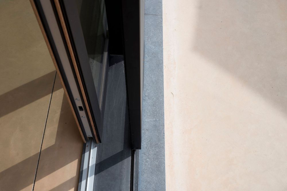 Close-up of modern sliding door track system in brushed metal finish.