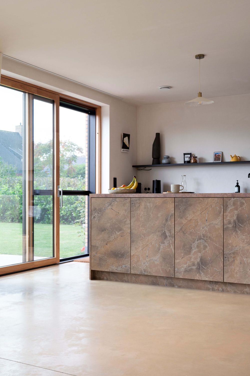 Spacious modern room with large windows and stone-textured wall panels offering panoramic views.