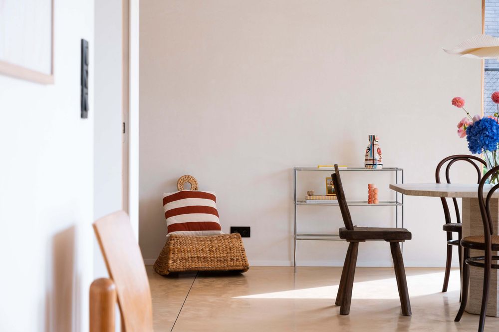 Modern minimalist living room interior with white walls, wooden furniture and natural lighting.