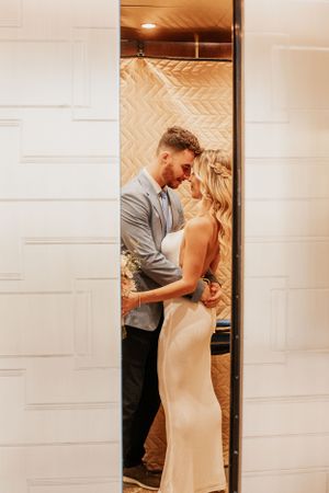 A romantic first look moment between newlyweds in a doorway.