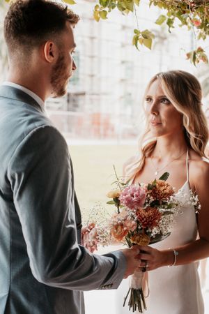 Intimate wedding moment with a bridal bouquet featuring pink and cream flowers.