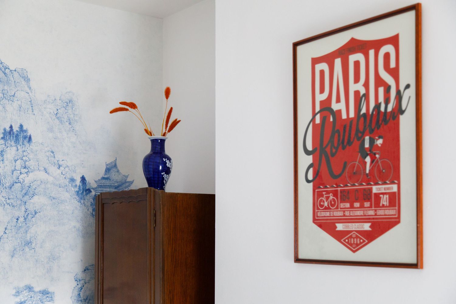 Modern room interior with red Paris poster and decorative blue wallpaper details taken during an interiors/lifestyle photoshoot..