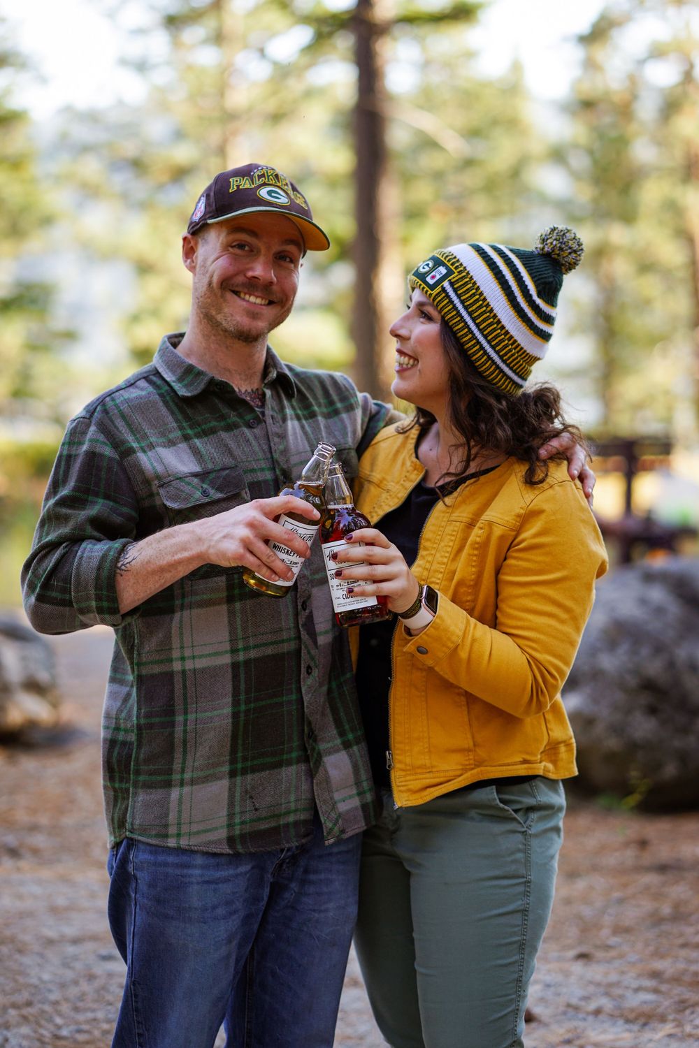 Happy couple toasts with drinks while enjoying outdoor adventure in winter attire.