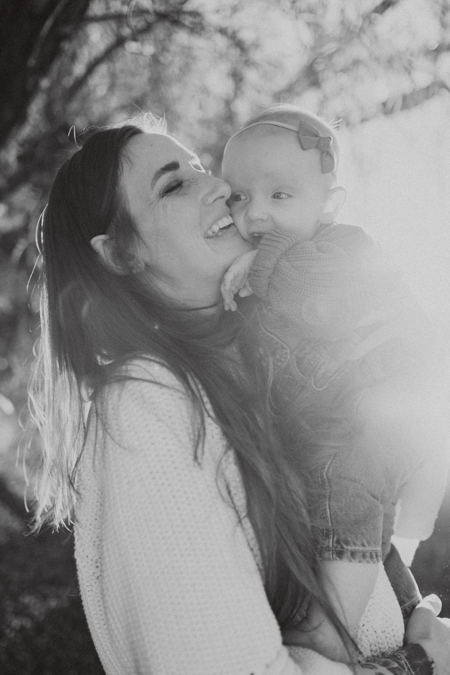 Black and white portrait of tender moment between parent and baby.