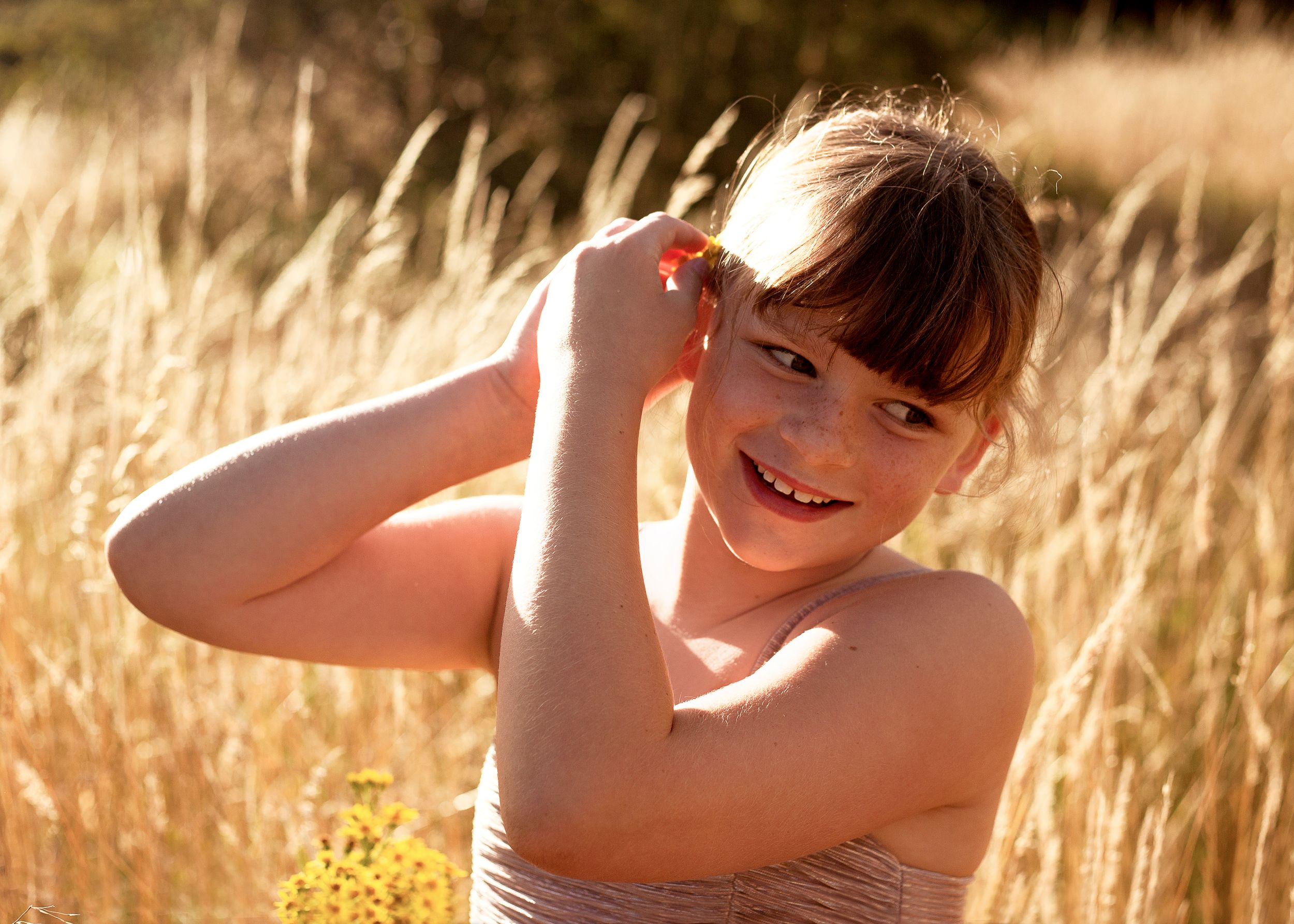 Young girl playing with her hair in beautiful sunset setting