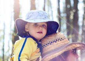 Beautiful backlit photograph of baby boy on his father's shoulders
