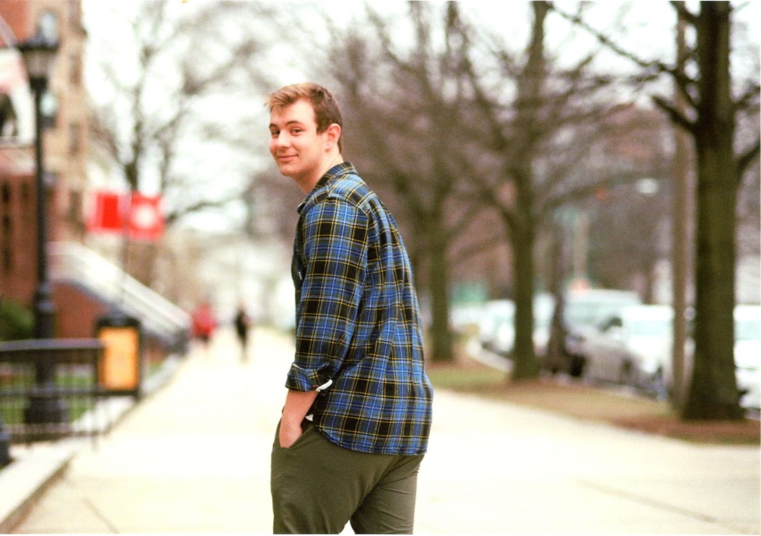 Young photographer, Daniel Bowler, candid photo looking over shoulder to camera and smiling.