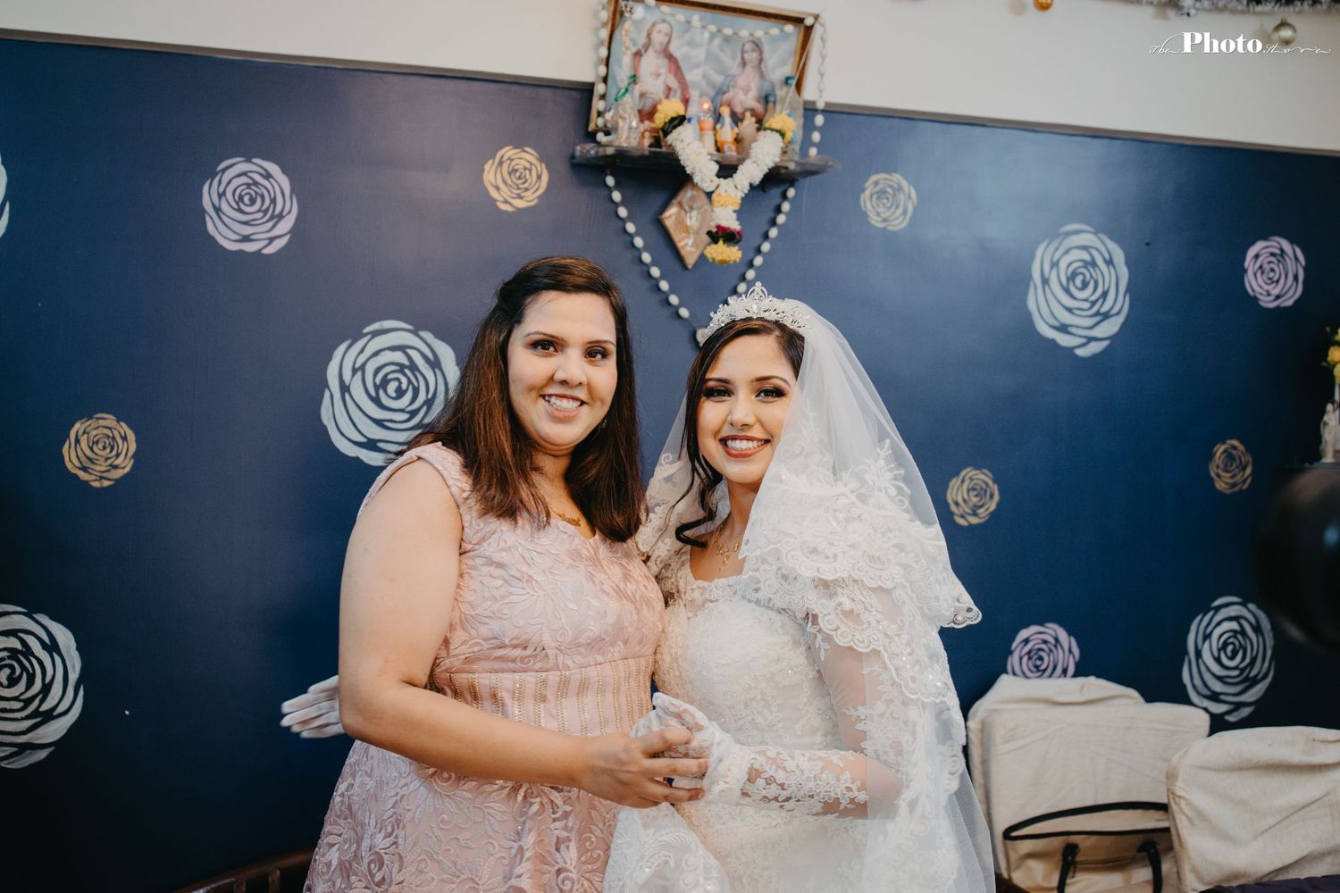 Candid wedding moment with guests celebrating against blue floral backdrop.