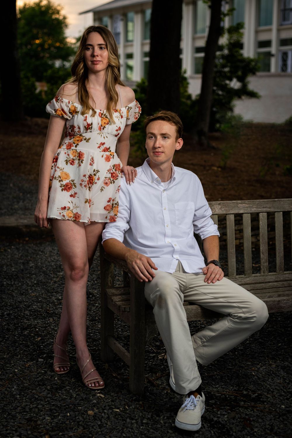 Stylish couple posing on outdoor bench in coordinated summer attire.