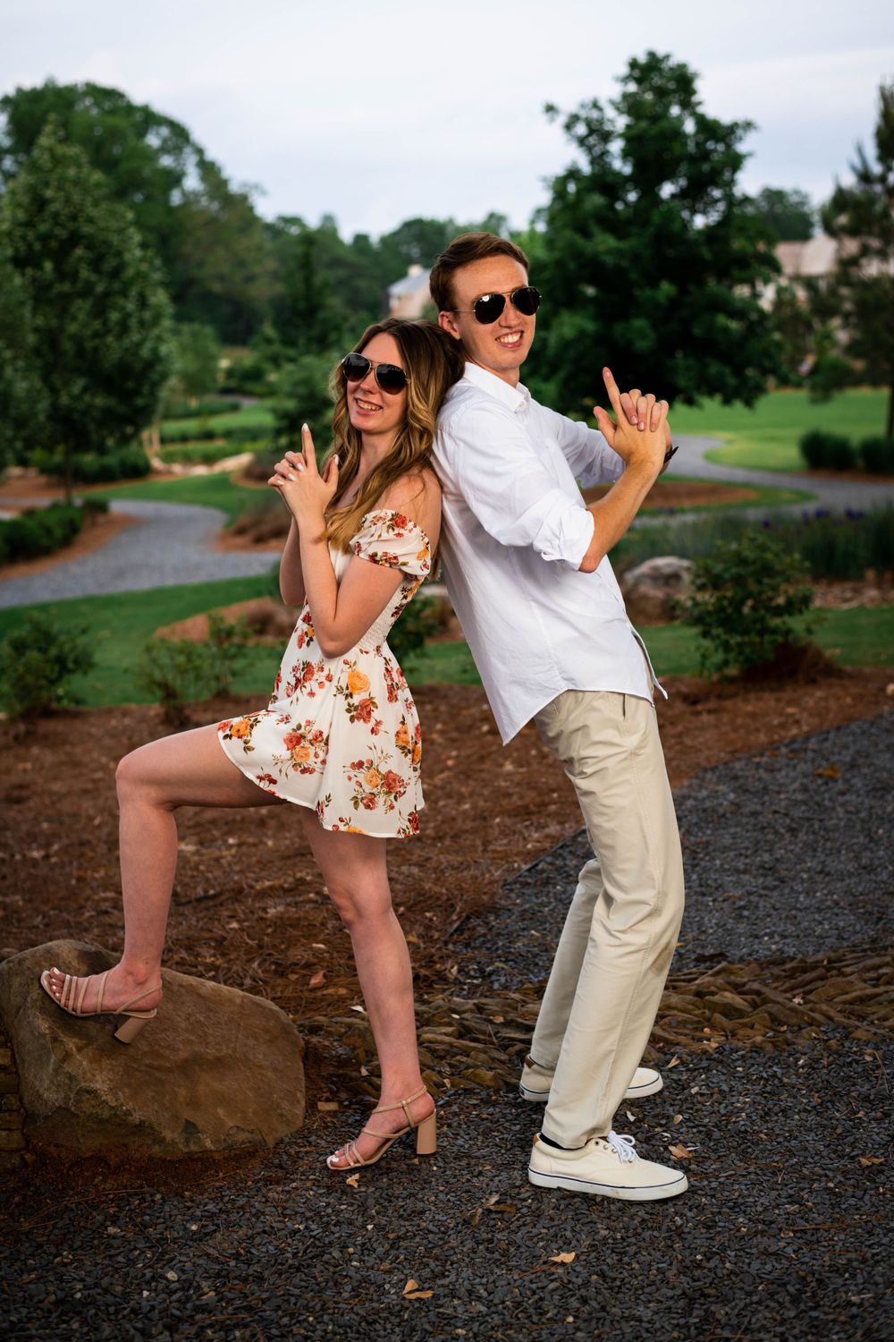 Playful couple striking fun poses outdoors while wearing sunglasses.