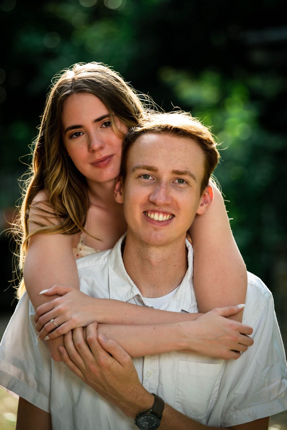 A loving couple shares playful embraces and smiles during an outdoor portrait session.
