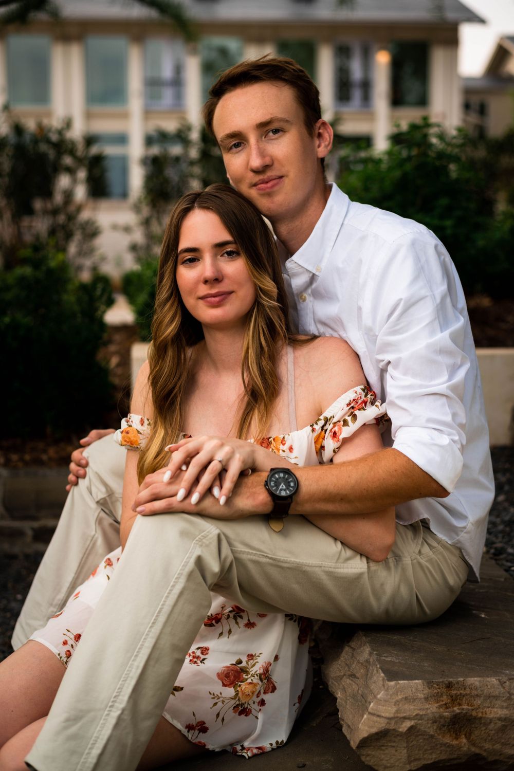 Couple poses casually on stone steps during their outdoor engagement photo session.