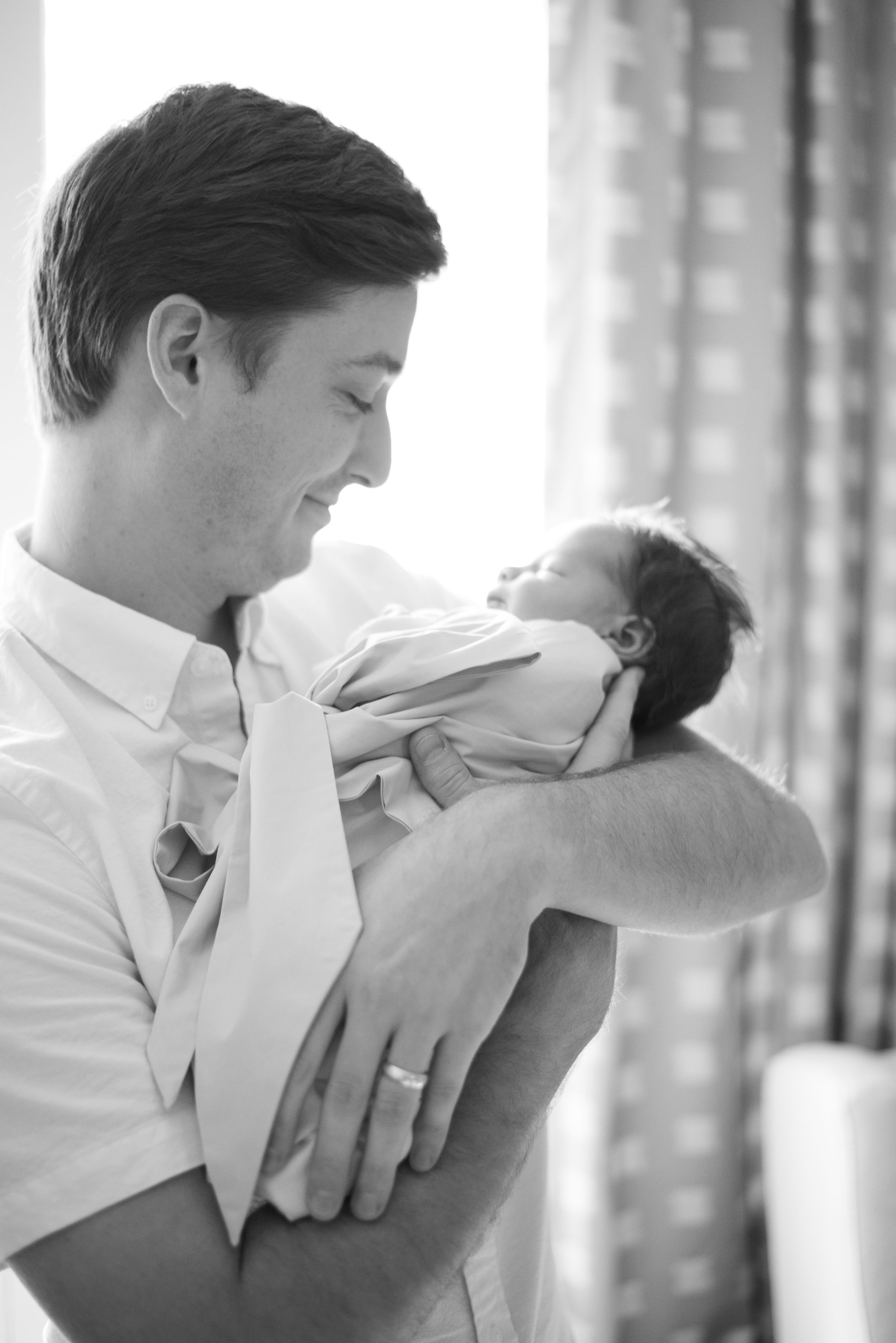 Daddy and baby boy. Newborn baby wrapped in a new father's arms during Houston newborn photography session