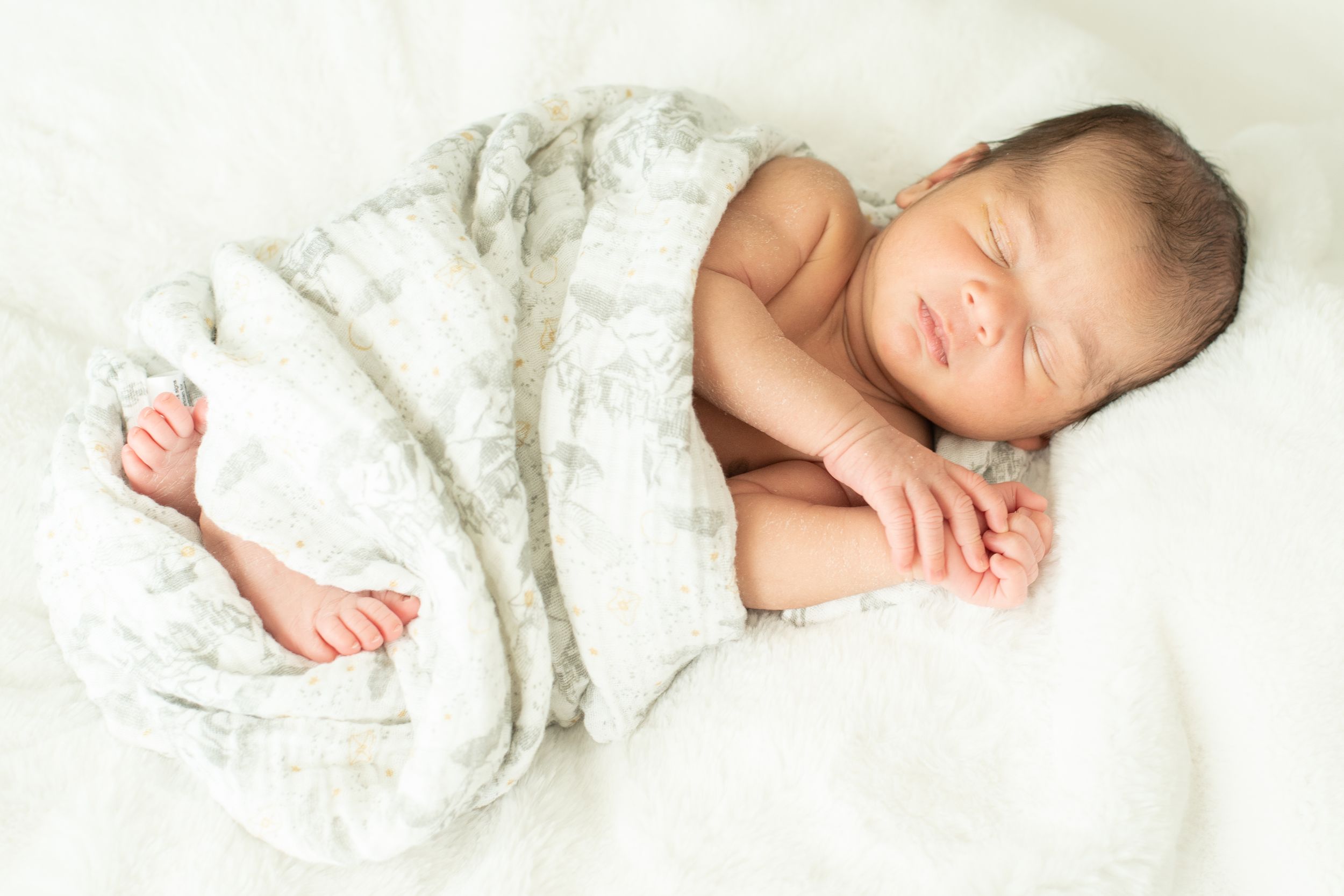 precious baby. Newborn baby wrapped in soft cream blanket during Houston newborn photography session