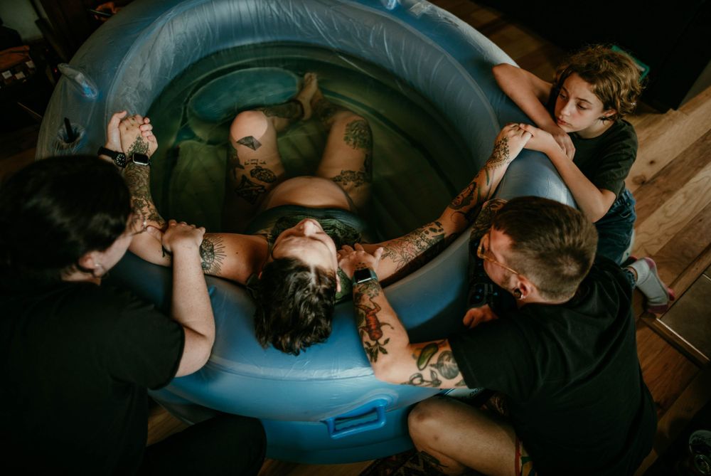 queer home water birth image midwife and partner support child present birth photographer kimberly marie kimble portland