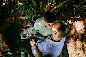 pov from above of white couple kissing on bench at rose garden portland oregon family photographer kimberly marie kimble