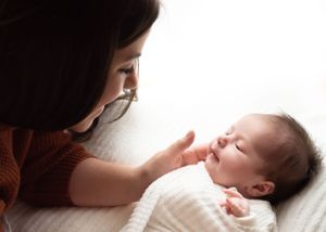 Gentle moment between caregiver and sleeping infant.