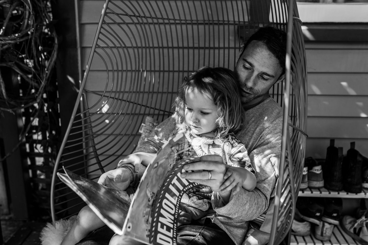 Black and white photo of a quiet reading moment shared between two people.