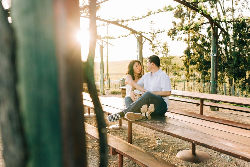 Engaged couple sitting on a picnic bench at sunset in San Luis Obispo, CA