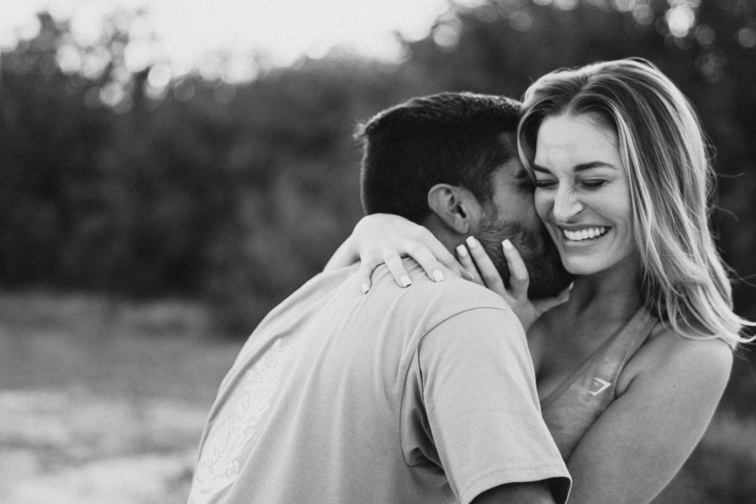A happy couple at a park in palm beach embracing each other during sunset