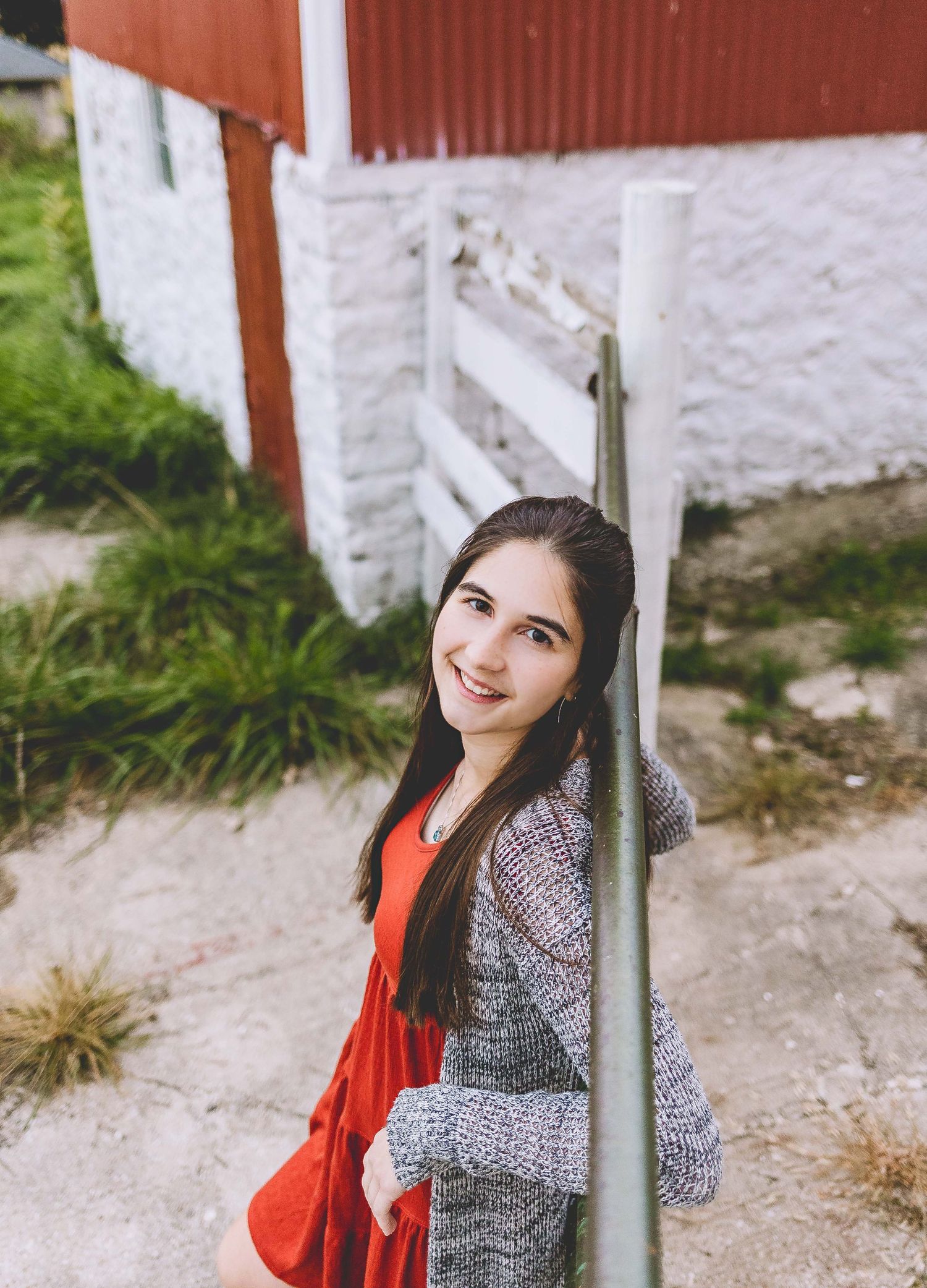 senior girl photoshoot at barn located in hartland wisconsin looking at camera and smiling