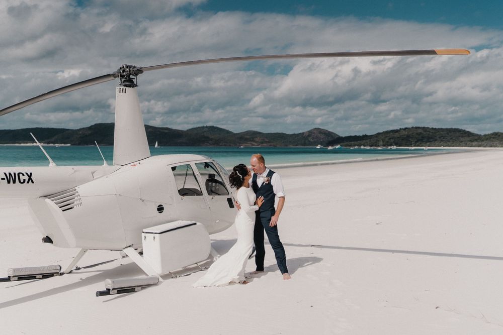 Couple photographed with helicopter on Whitehaven Beach after eloping.