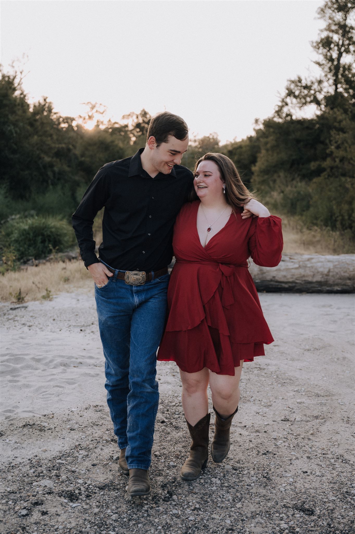 A couple walks together on rocky ground wearing coordinated casual outfits.