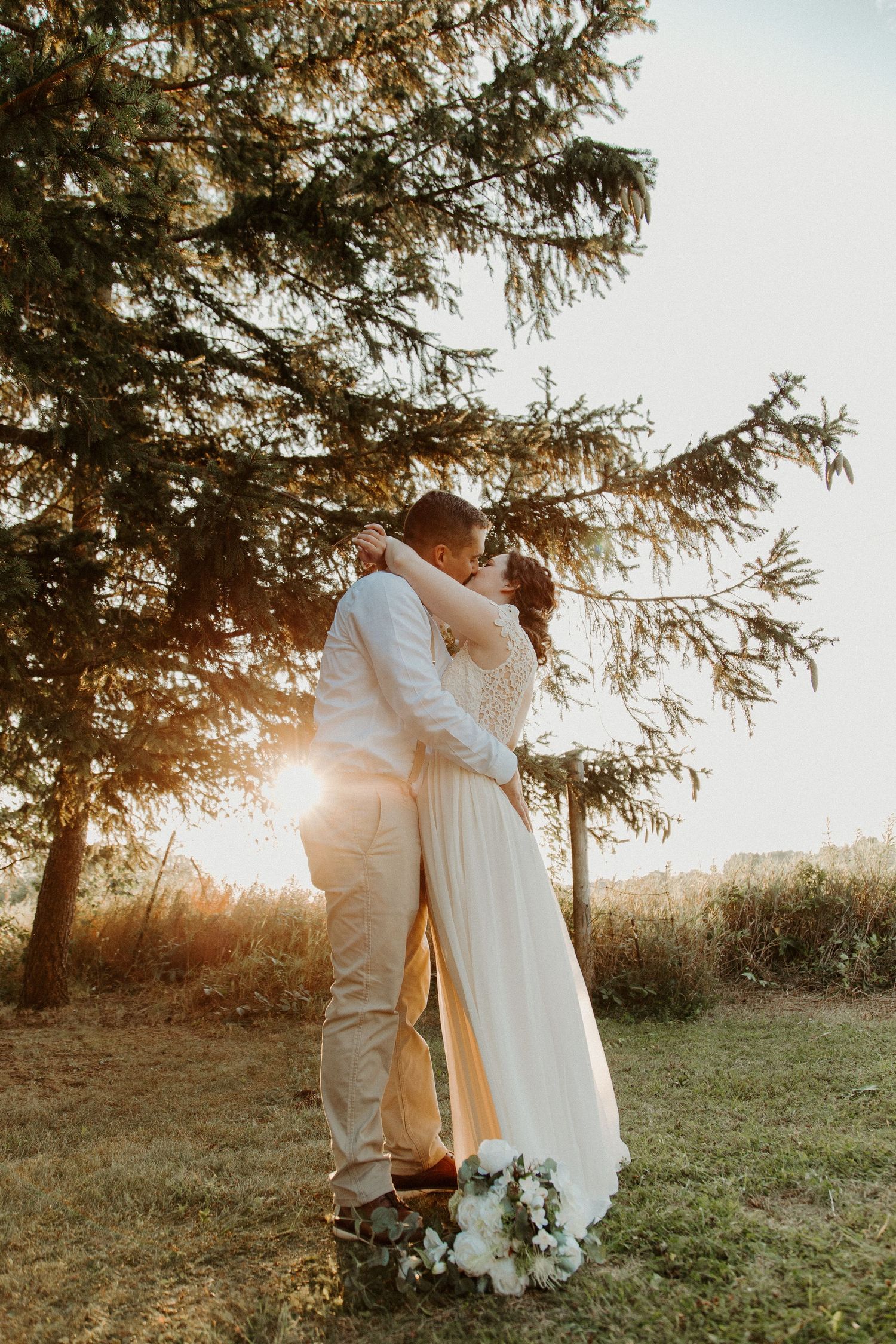 sunset, bouquet and a couple in love on their wedding day