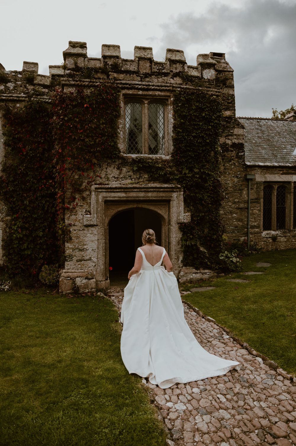 Bride walking towards a castle venue at Hareston Manor