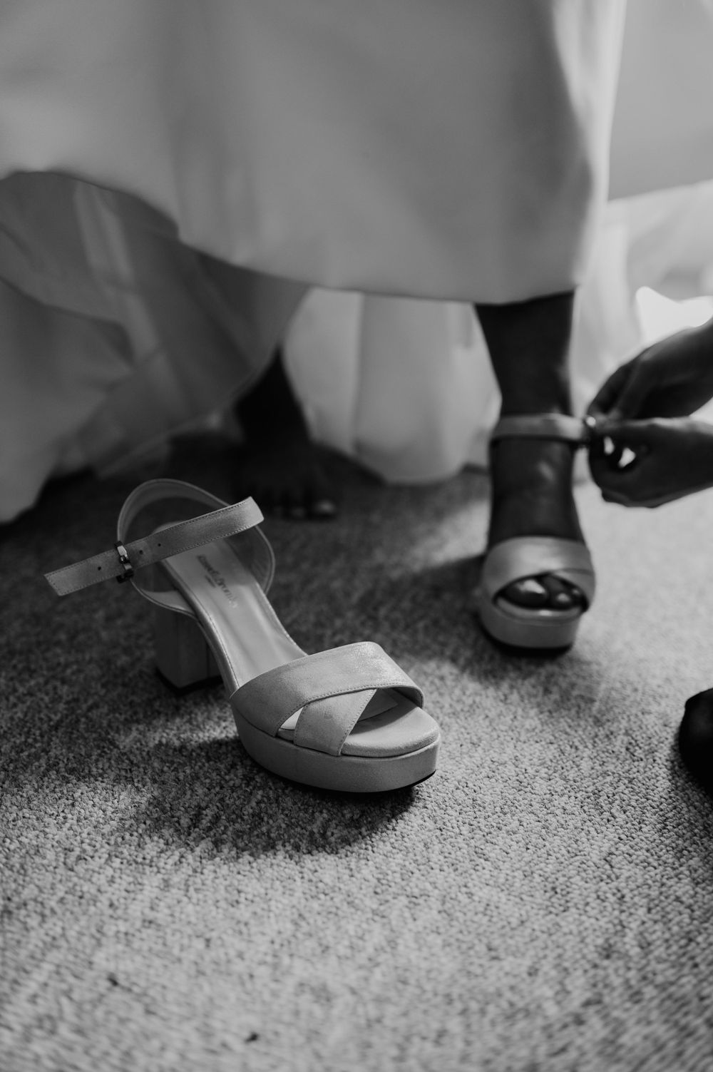 A bride putting her wedding shoes on at Hareston Manor