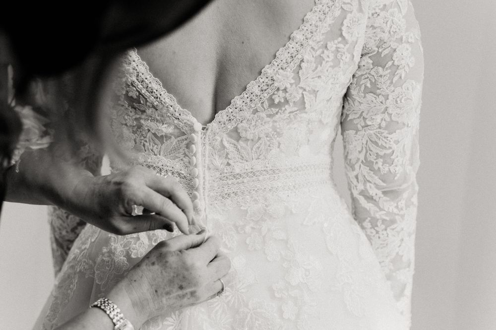Mother of the bride doing up the brides dress at Crowcombe Court