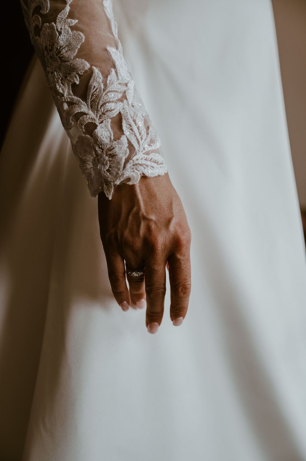A close up of the brides ring on her hand in her wedding dress at Tregenna Castle