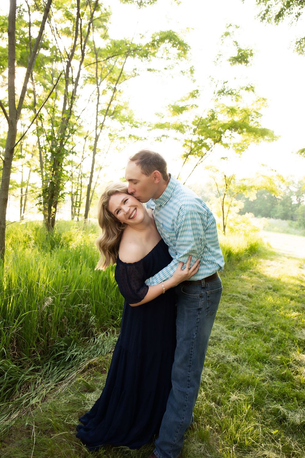 A joyful moment captured between a couple laughing in nature.