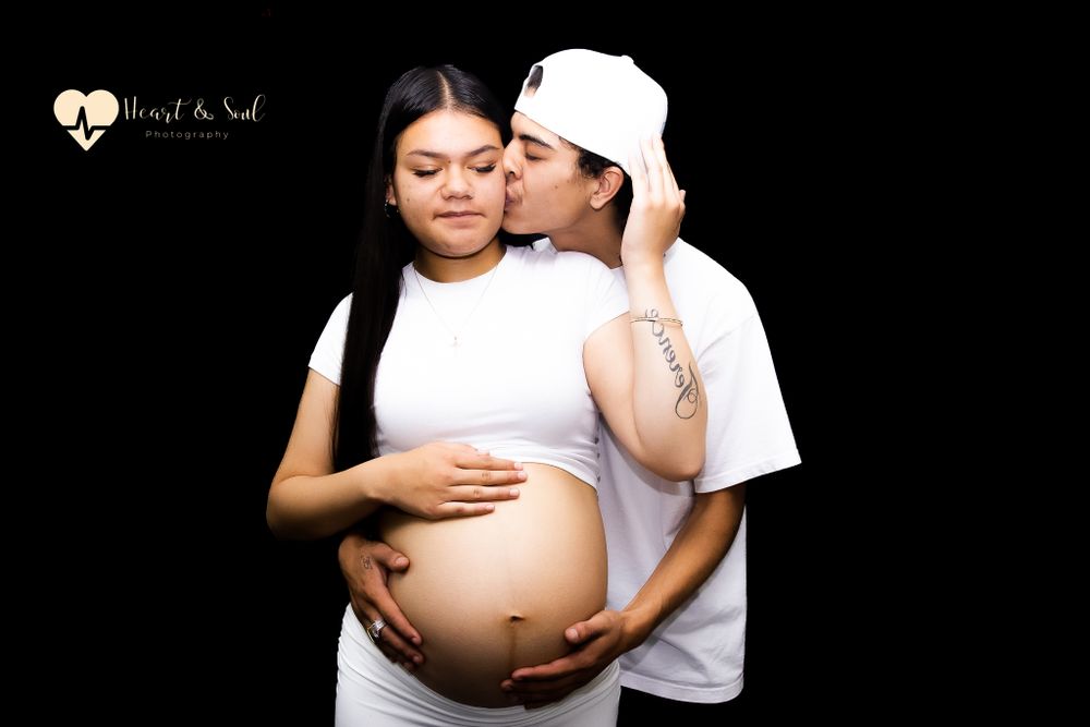 lady and man holding pregnant baby bump