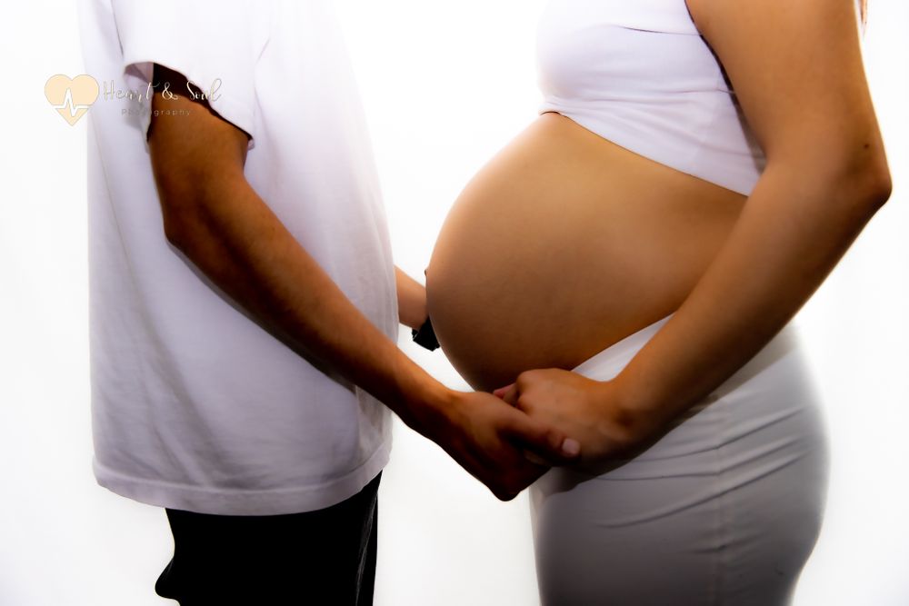 pregnant baby bump and hands holding