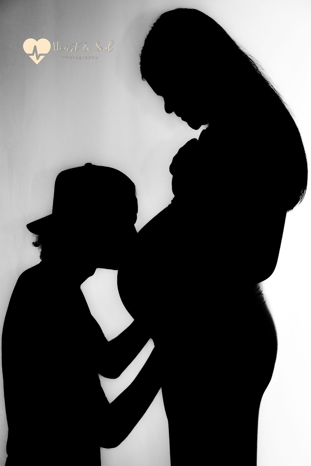 lady and man kissing pregnant baby bump