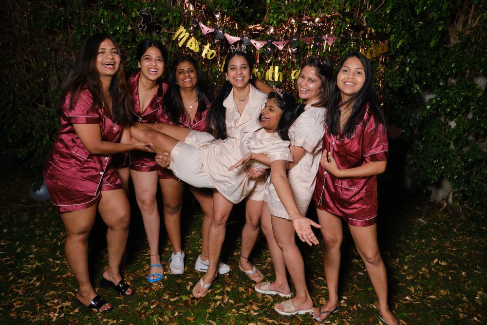 A group in matching satin robes poses together during a nighttime celebration.