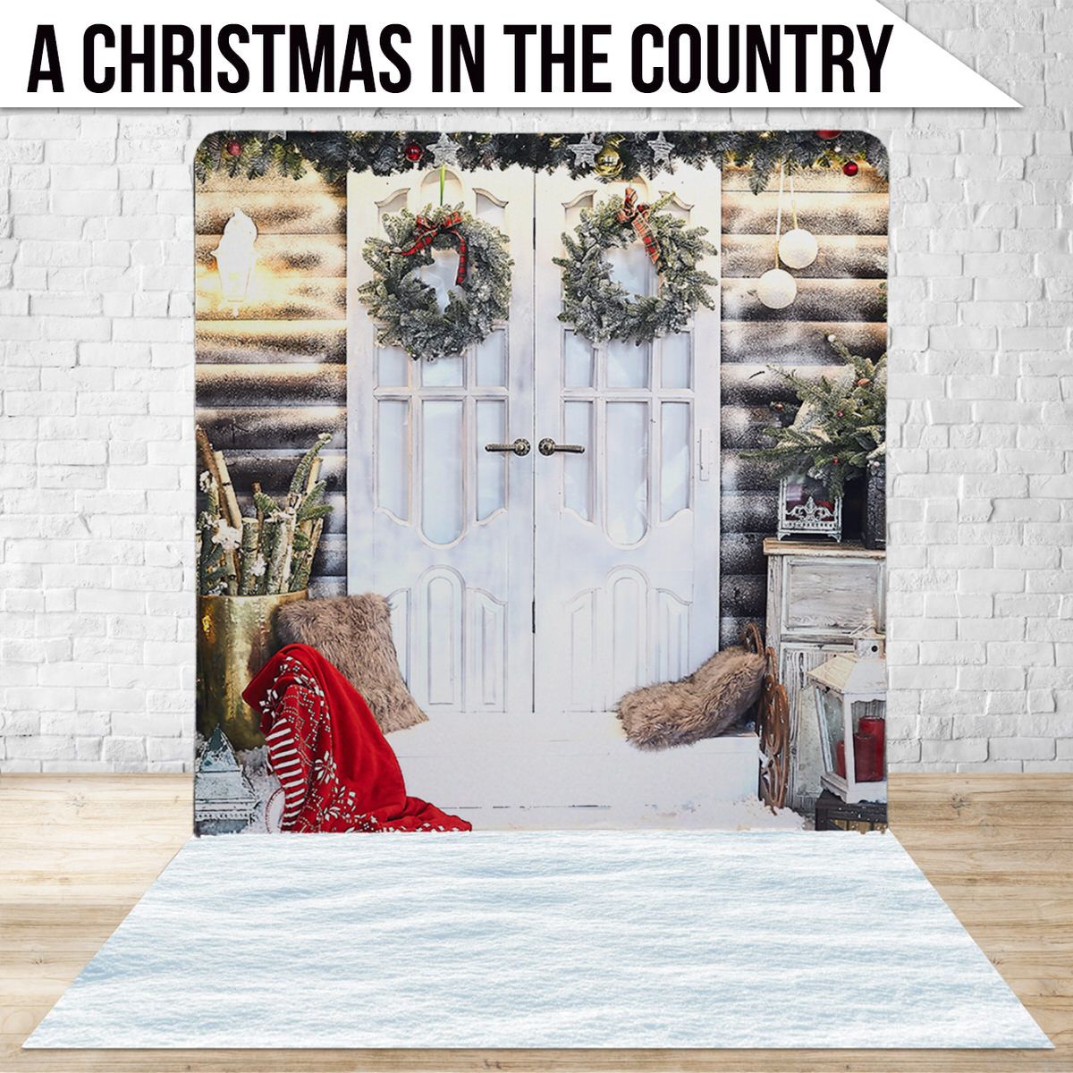 Rustic white double doors decorated with Christmas wreaths and a red blanket in a snowy country setting.