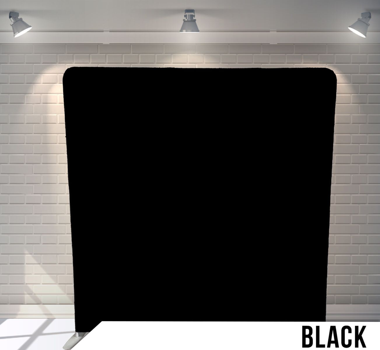 Solid black photography backdrop mounted on white brick wall with studio lighting.
