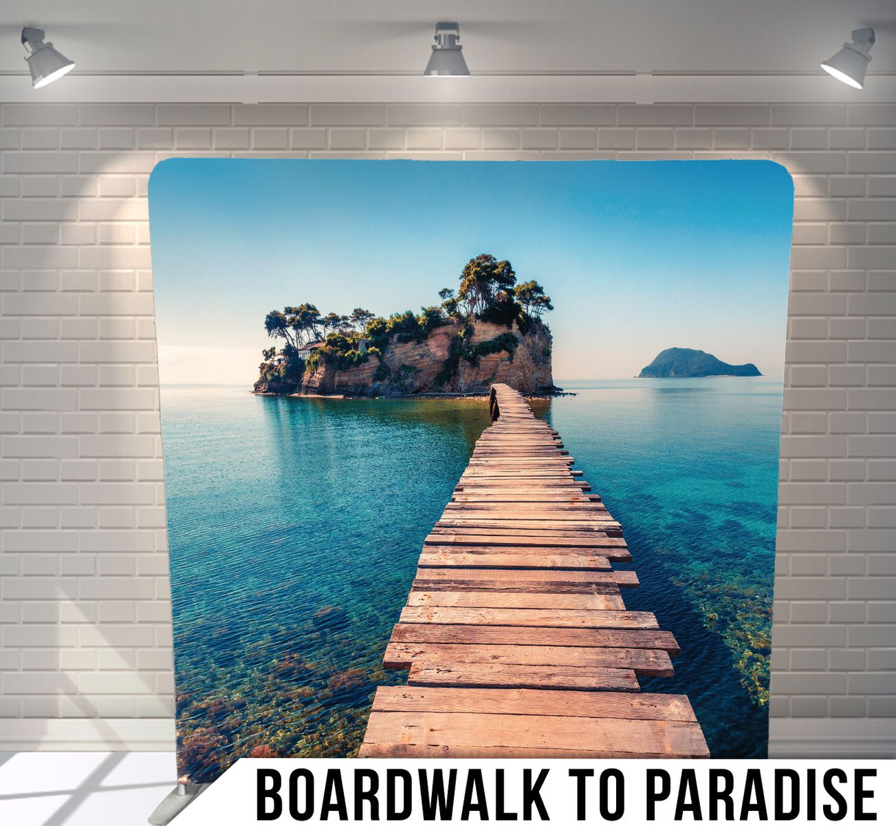Wooden boardwalk leading to a small tropical island surrounded by crystal clear turquoise waters.
