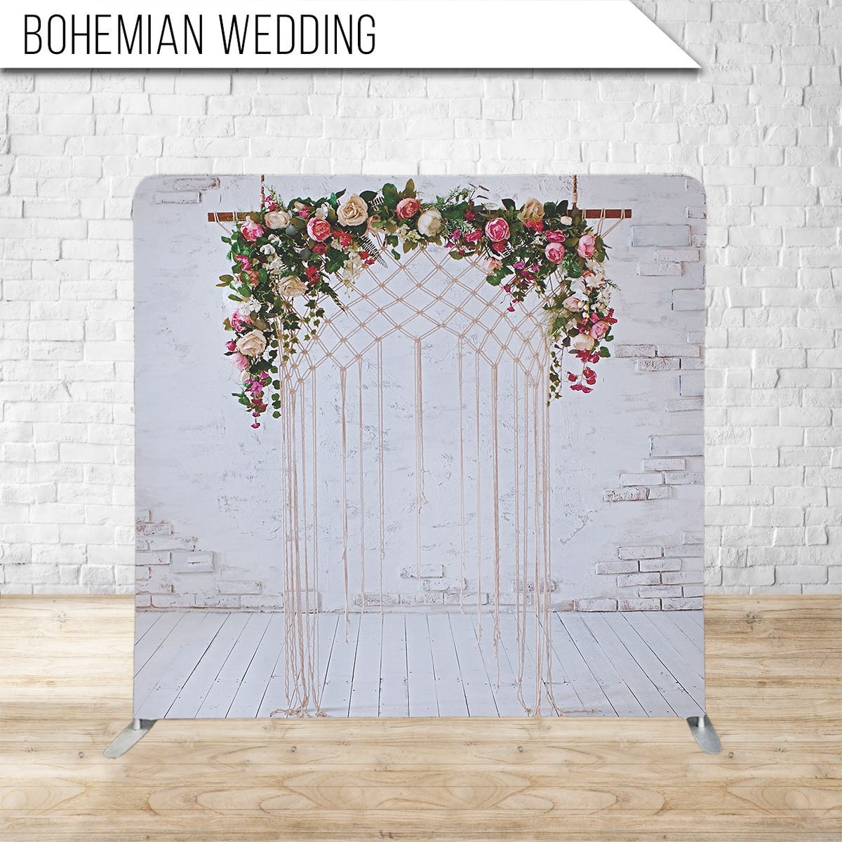 Wedding arch backdrop with pink flowers and geometric gold lines against a white brick wall.