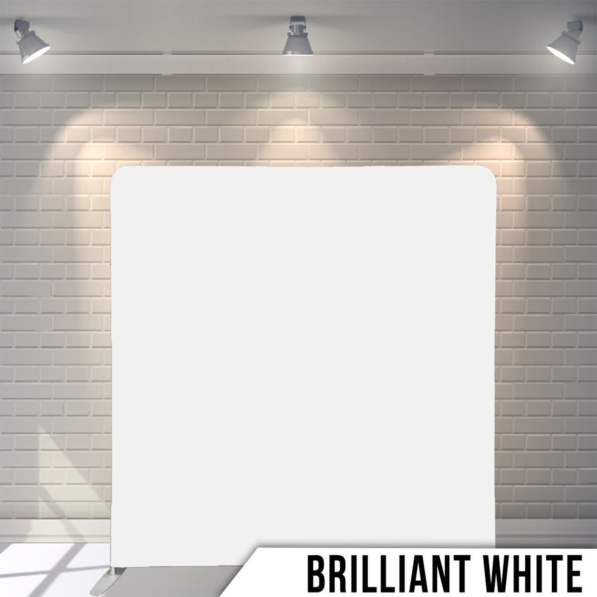 Clean white backdrop with studio lighting against gray brick wall.