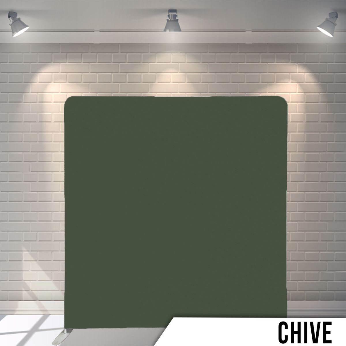 Solid chive green colored photography backdrop against a white brick wall.