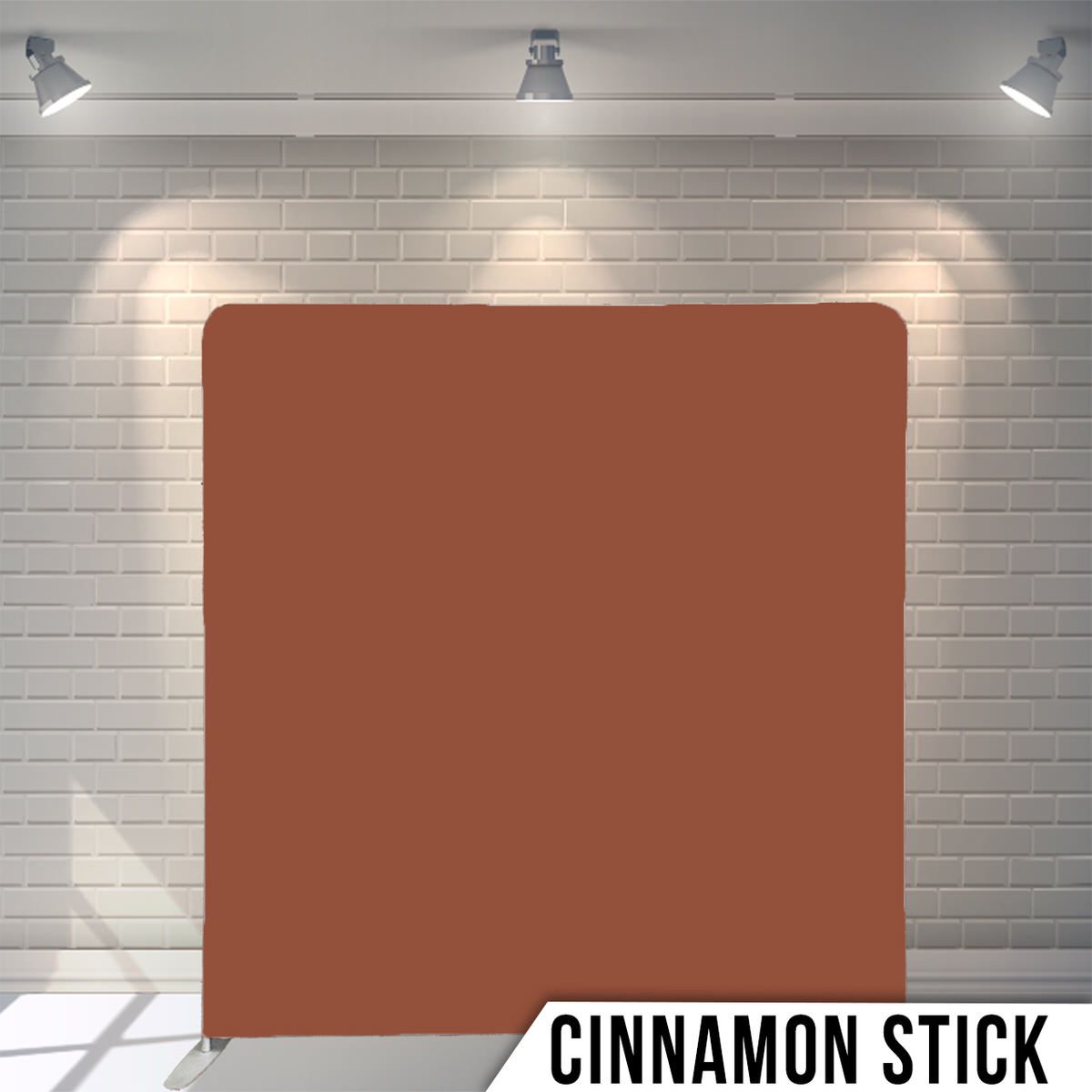 Solid cinnamon brown photography backdrop against white brick wall with studio lighting.