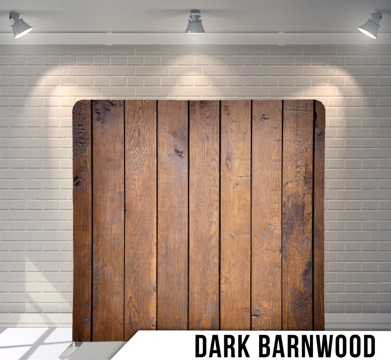 Rustic brown barnwood planks photographed against white brick wall with dramatic spotlight lighting.