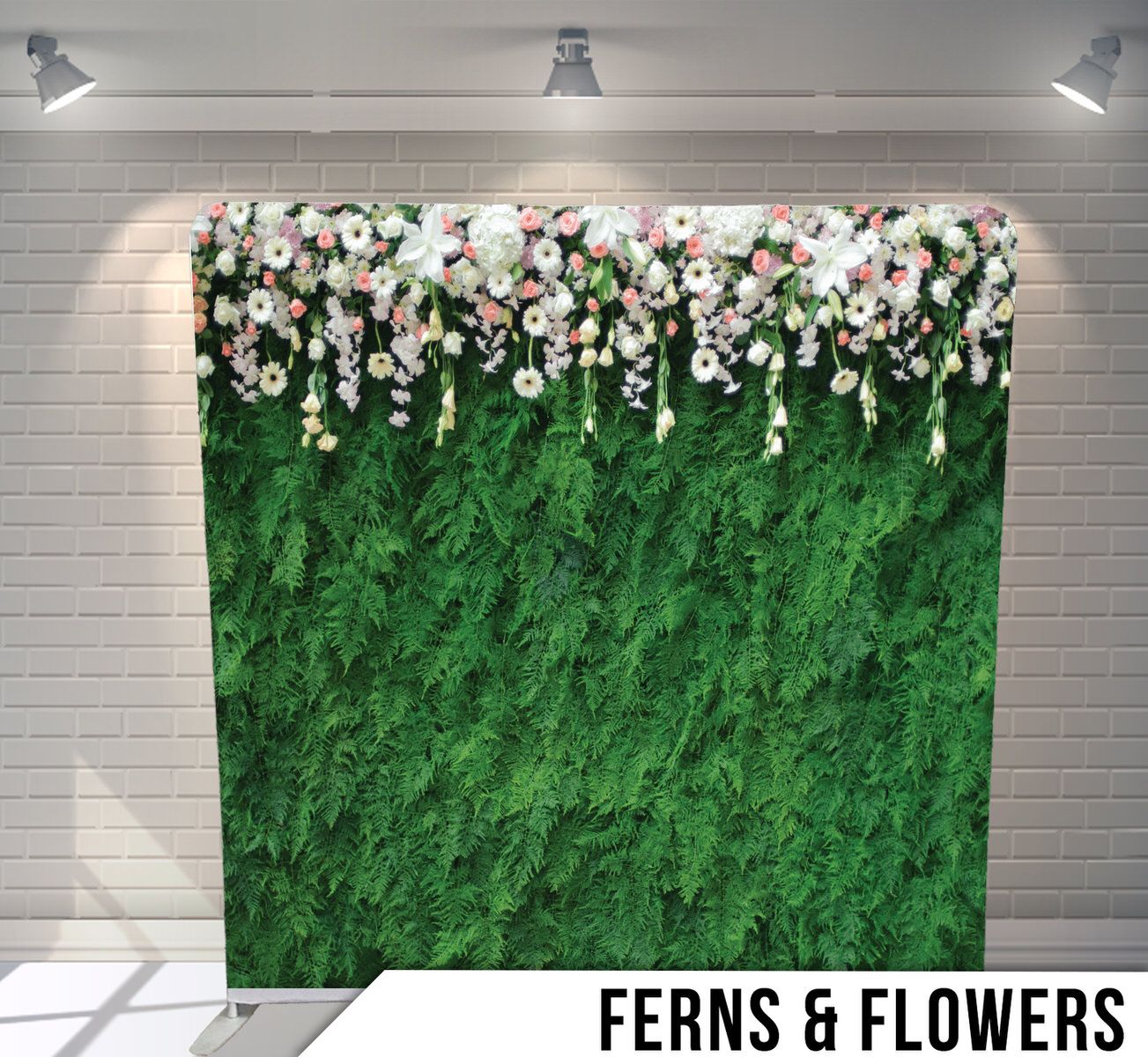 A green floral backdrop with white and pink flowers cascading from the top against a textured green wall with spotlights.