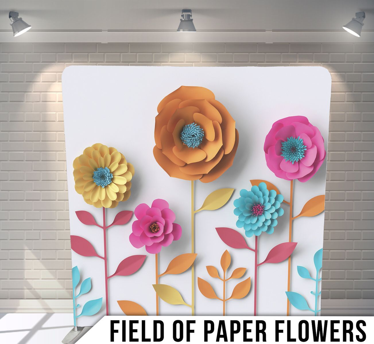 Colorful handmade paper flower wall art installation with pink, orange, yellow and turquoise blooms against white brick backdrop.